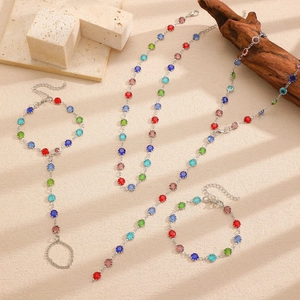 Artistic detail of colorful gemstone jewelry set with necklace and bracelets on natural stone