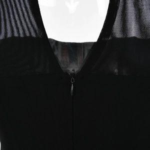 Detail of sheer mesh patchwork fabric with a hidden back zipper on a black dress