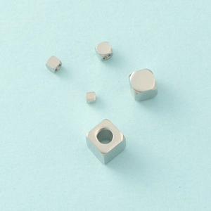 Macro shot of mirror-polished stainless steel cube beads with holes for DIY jewelry