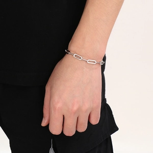 Close-up of a silver stainless steel link bracelet worn on a man's wrist for a daily look