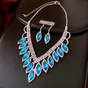 Macro view of crystal encrusted drop fringe necklace with marquise-cut blue gemstones
