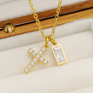 Luxurious gold cross necklace with December birthstone pendant on beige velvet