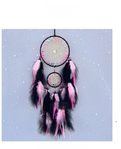 Detail of double-ring dream catcher with black and pink feathers and moon pendant