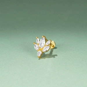Macro view of gold marquise cut crystals in a floral cluster stud earring on green surface