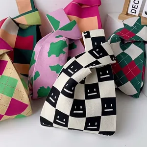 Various colorful checkered and patterned knitted knot bags in soft fabric textures