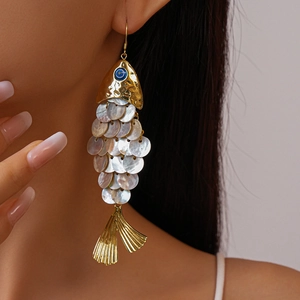 Golden fish tassel earrings with shell discs shown on model for a seaside vacation look