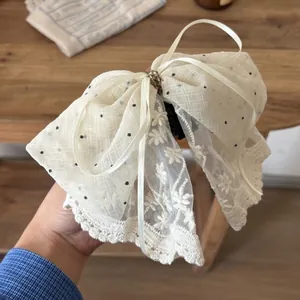 Creamy white lace bow hair claw clip with black polka dots and floral embroidery