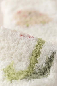 Close-up of thick coral fleece fabric showing soft tulip pattern and warm texture