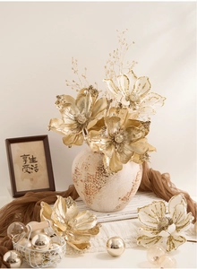 Artificial Christmas magnolia in gold and white with a vintage ceramic vase for home decor