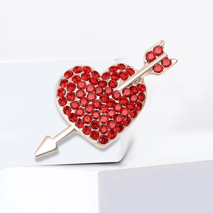 Elegant gold heart brooch with red rhinestones on a white geometric display stand
