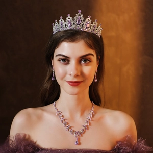 Close-up of bridal jewelry set with purple crystals, silver crown and earrings