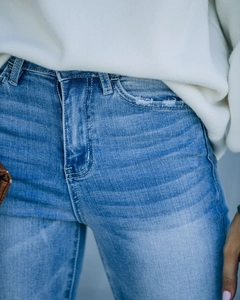 Détails d'un jean taille haute avec tissu délavé et fermeture éclair métallique durable