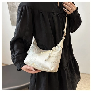 Detail of silk-like floral pattern handbag styled with a minimalist black dress