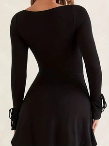 Back view of black slim-fit dress with square neck and lace-up cuffs on white background