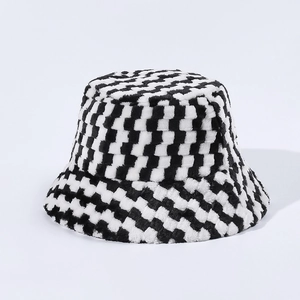 Détail d'un chapeau bob en peluche avec motif damier noir et blanc et texture douce