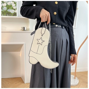 Close-up of boot-shaped cream white crossbody bag with chain strap and star detail