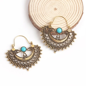 Macro detail of bronze fan-shaped earrings with turquoise beads and hollow carvings