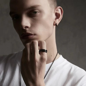 Detail of men's black spinning ring with chain inlay and matching minimal hoop earring