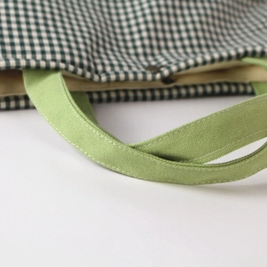 Green plaid canvas tote bag with reinforced handles and magnetic metal closure details