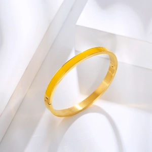 Detailed view of golden stainless steel bangle with yellow enamel on geometric block