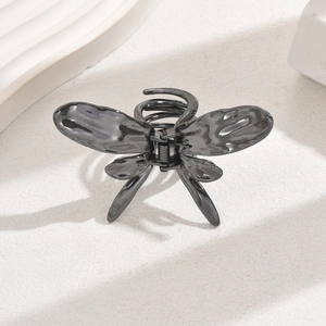 Minimalist liquid metal butterfly hair claw clip with irregular texture on white background