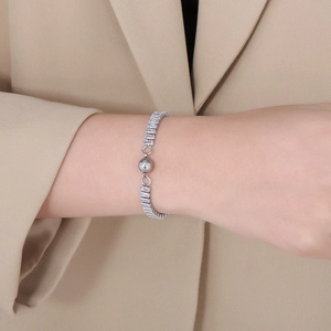 Détail du fermoir magnétique d'un bracelet en zircone argenté porté au poignet