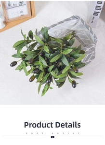 Detailed view of artificial olive branch with green leaves and dark purple fruit in a basket