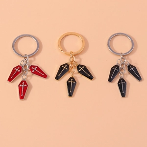 Detailed close-up of metal coffin keychains with cross patterns in red and black colors