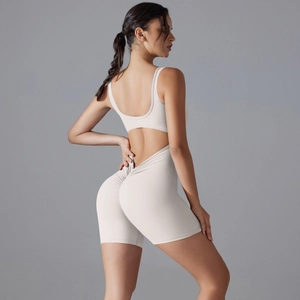 Détails du dos nu croisé et design fessier plissé de la tenue de yoga beige