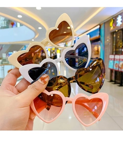 Detailed view of heart-shaped sunglasses with UV400 lenses in pink and tortoiseshell