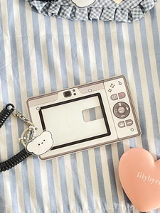 Macro view of camera-shaped acrylic card holder with spring lanyard and bear charm