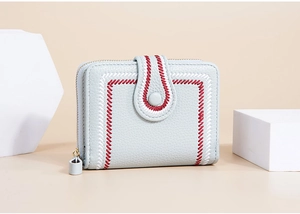Detail view of light blue leather wallet featuring red and white contrast stitching and a snap closure