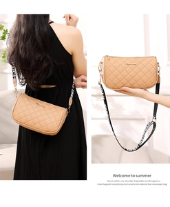 Close-up of beige quilted PU leather shoulder bag with a stylish lettered wide strap