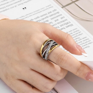Gros plan d'une bague multicouche en or et argent avec strass sur la main d'un modèle