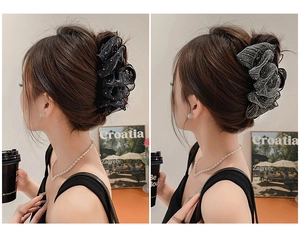 Détail d'une pince à cheveux élégante en dentelle noire avec perles et fleur en résille