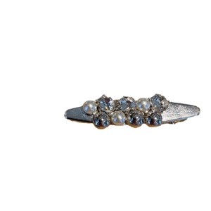 Elegant silver metal bow hair clip with faux pearls and rhinestones on white background