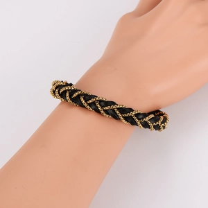 Men's braided leather bracelet with intertwined gold chain on a model's wrist