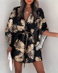 Detail of V-neck summer dress with gold tropical leaf print and adjustable waist tie