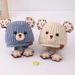 Detail of blue and beige knit bear hats showing soft wool texture and cute ear flaps