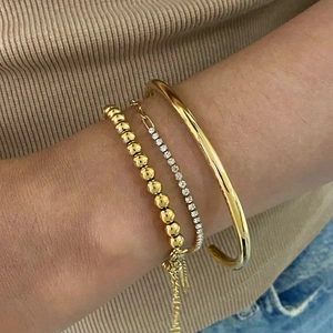 Ensemble de trois bracelets en acier titane doré avec jonc, perles et chaîne de tennis zircon