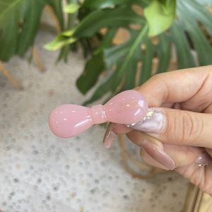 Close-up of a pink bow-shaped resin hair clip with gold Barrette La France engraving