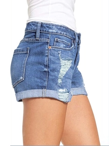 Detalle de los pantalones cortos de mezclilla azul con rotos y dobladillo doblado en el lado