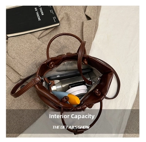 Internal capacity of dark brown soft leather cloud bag showing phone and cosmetics