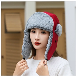 Detail of red winter trapper hat with grey faux fur lining and plush ear flaps