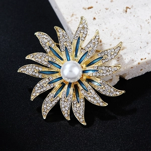 Detailed macro view of sunflower brooch with blue enamel petals and center pearl inlay