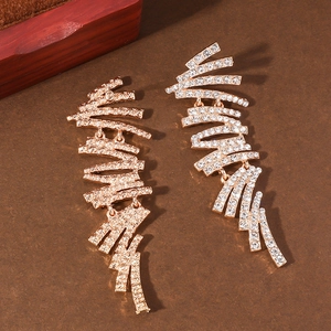 Detailansicht asymmetrischer Gold-Quastenohrringe mit Strassbesatz und Metalltextur