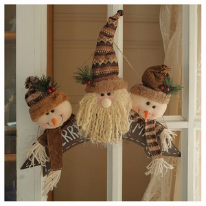 Detail of Christmas wall hanging featuring plush Santa and snowmen with red berries