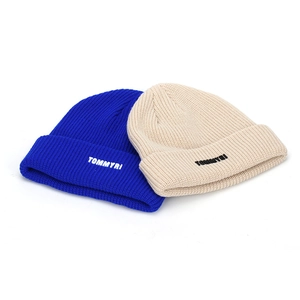 Royal blue and beige knit beanie hats with TOMMYRI embroidery on white background