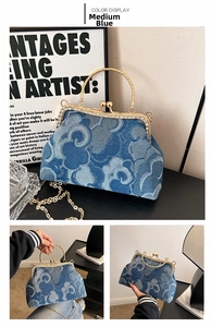 Close-up of denim bag with rhinestone metal frame, gold ring handle and chain