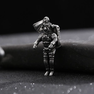 Macro detail of silver titanium steel astronaut pendant with vintage textured finish
